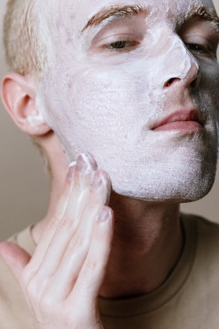 Close-up of a man applying facial cleanser, emphasizing skincare and cleanliness.